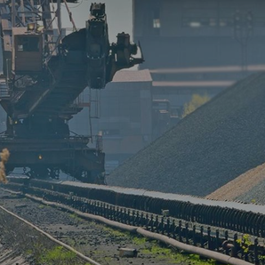 Industrial conveyor system and heavy-duty excavator operating in a plant facility for material handling and process engineering.