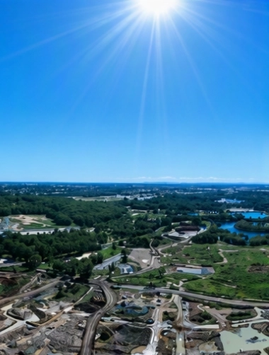 Aerial view of a large construction site with earthworks and access roads