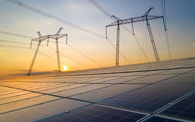 Solar panels and grids against orange sky