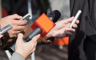 36767037_News interview holding an orange microphone