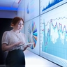Businesswoman studying graphs on screen