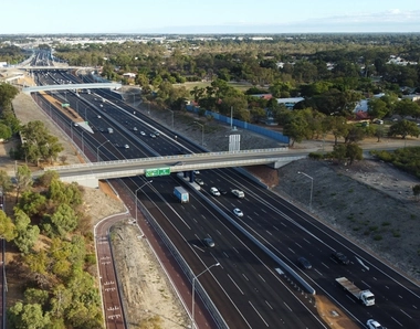 Vue aérienne du projet Tonkin Gap avec autoroute à plusieurs voies, échangeurs modernes et pistes cyclables bordées d’arbres.