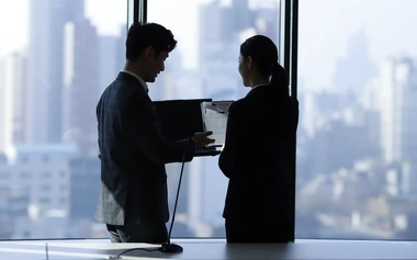 Business people using laptop in meeting