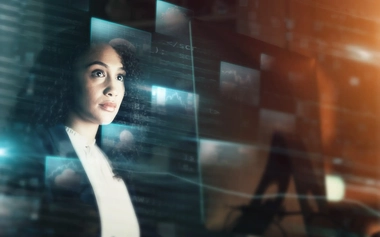 woman in front of multiple computer screens showing data