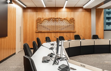 Meeting room with curved desks chairs and wood wall panel