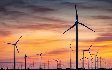 wind turbines against orange sunset