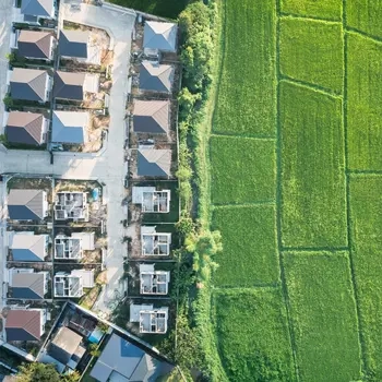 aerial view of a green field surrounded by houses