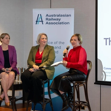 Panel speakers seated during a railway industry discussion event.