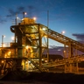 Mining processing plant with conveyors illuminated at dusk