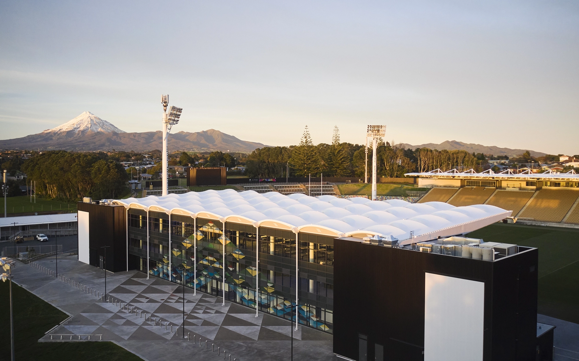 Stadium building with mountains and snow capped peak in background