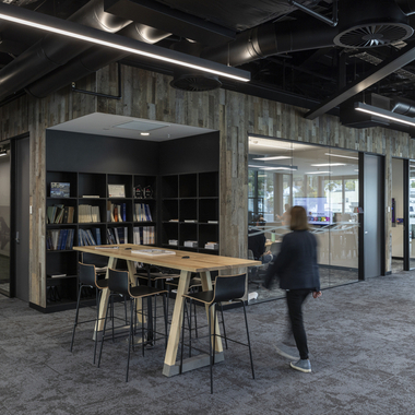 Open workplace area with glass meeting rooms and shared table.