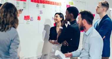 Para siswa sedang meninjau papan tulis.