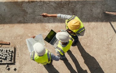 Engineers using laptop at a construction site