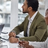 AdobeStock_620247754_Businessman, laptop and teamwork with documents in meeting for strategy, planning or proposal at office. Corporate man, senior or CEO talking to team in leadership or training staff at the.jpeg