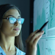Getty Image_973708270_Businesswoman studying graphs on an interactive screen in business meeting