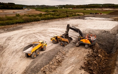 Aerial view of excavator and truck gathering earth