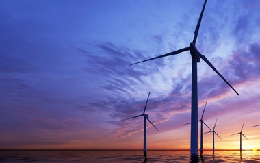 Offshore wind turbines in the ocean at sunset
