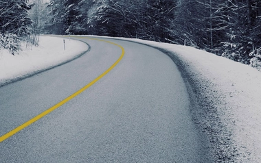 asphalt road surrounded by snow 