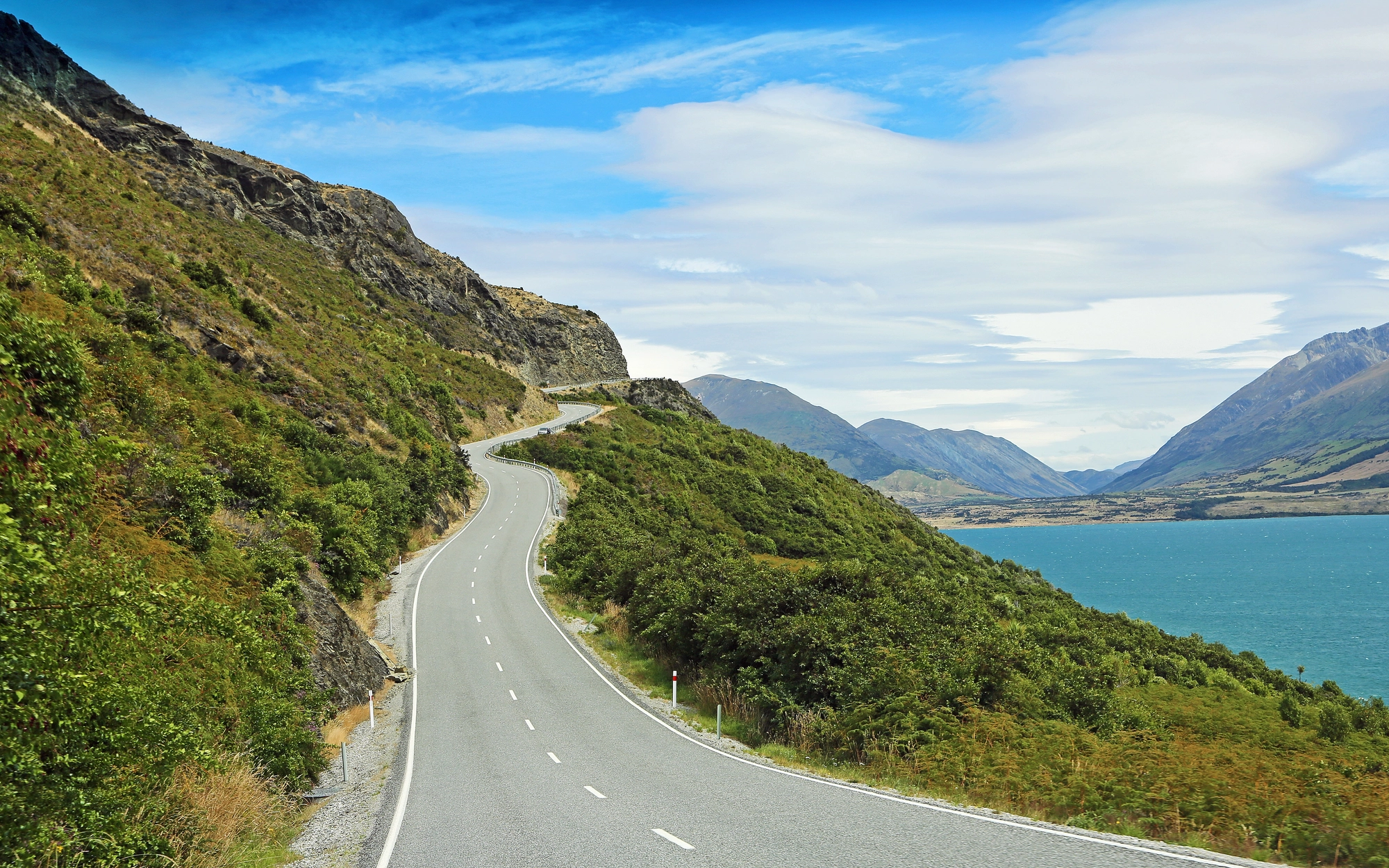 Winding road along lake and mountains