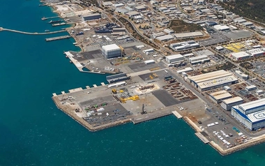 Aerial view of a waterfront industrial precinct with wharves and large buildings.
