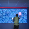 Geologist studying graphical display of oil and gas bearing rock on screens