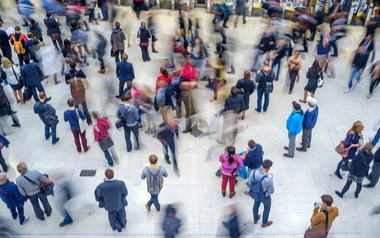 Commuters walking through a crowded train station with motion blur