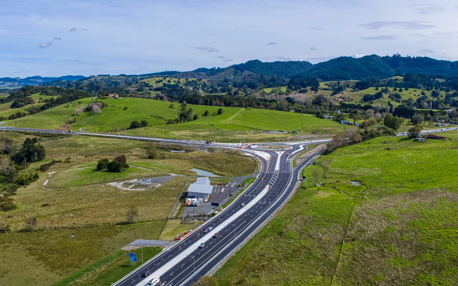 Highway interchange through green rural landscape from above