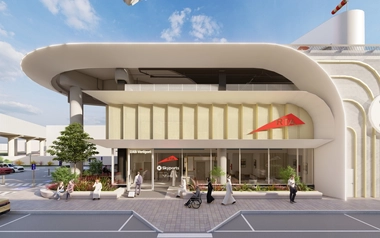 Street-level view of a Dubai vertiport showing the entrance, pedestrians, landscaping and adjacent roadway.