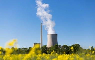 Coal-fired power plant with cooling tower and rapeseed in the foreground