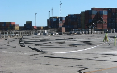 Cracked and displaced pavement at a container port after an earthquake.