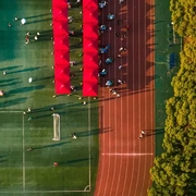 AdobeStock_636426681_Aerial-view-of-a-large-running-track-surrounded-with-lush-greenery