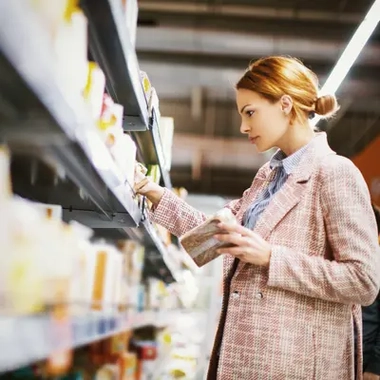  GettyImages_1095504764_Young woman buying gluten free bread at supermarket
