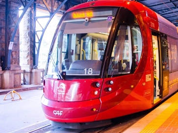 red CAF Urbos 3 light rail vehicle