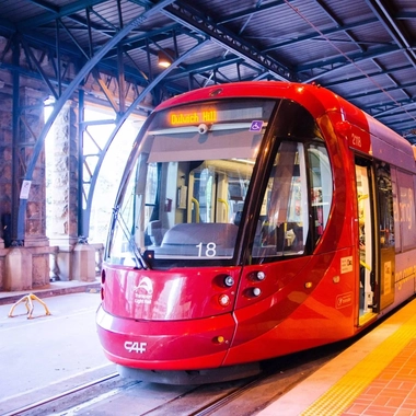red CAF Urbos 3 light rail vehicle