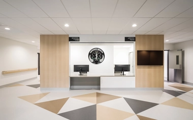 Reception area featuring cultural flooring motifs and timber protective wall panelling.