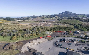 Aerial view of landfill site with waste areas buildings and surrounding hills