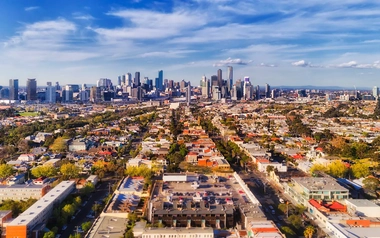 Aerial view of a vibrant cityscape with skyscrapers and residential houses.