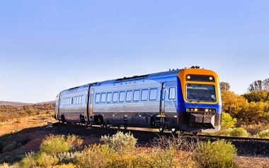 Train traveling on a railway track through a rural landscape
