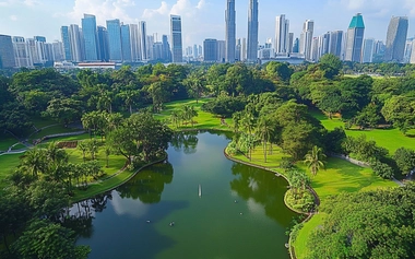 Aerial view of Ayala Triangle Gardens in the heart of Makati City, with the modern skyline of high-rise buildings towering in the background.