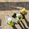 Engineers using laptop at a construction site