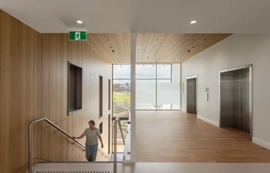 Stairwell and elevator lobby with wood walls and large window