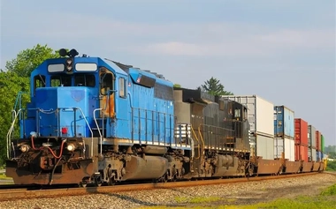 Two locomotives pulling a train of container cars