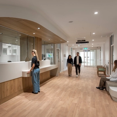 Reception area with desk and people walking along a corridor