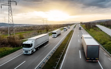 White trucks travelling on a highway
