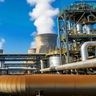 Industrial power plant with cooling towers emitting steam.