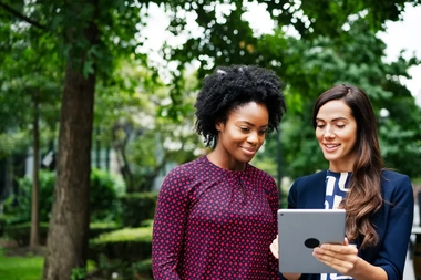 two women watching a tablet