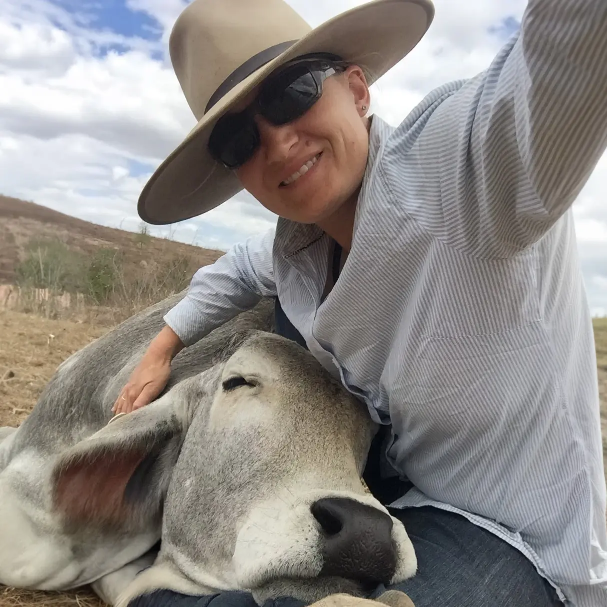 Jessica Newton on a farm with a cow