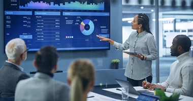 Woman presenting diagram on board in meeting room