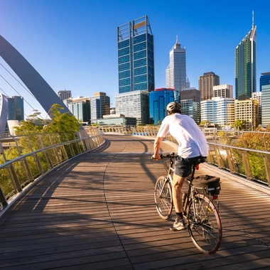 Cyclist on a bridge with city skyline
