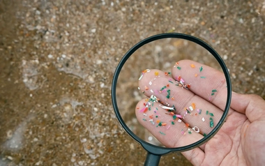 Microplastics in  water under a magnifying glass